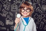 Happy,Little,Boy,In,Doctor,Costume,Holding,Sthetoscope,On,Dark