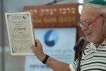 גדעון ממרוט מחזיק בתעודת ההוקרה למיכאל דק