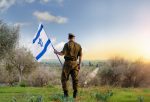 Israeli soldier with Israel flag against the sunset in the bloom